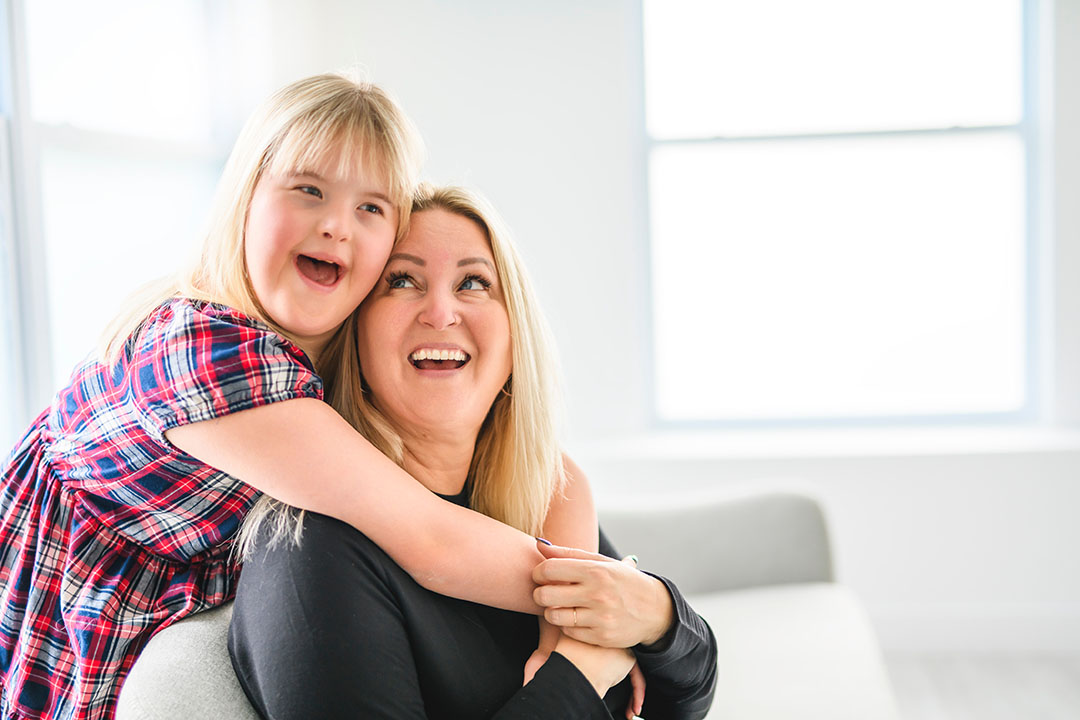 Daughter with down syndrome hugging her mother with love